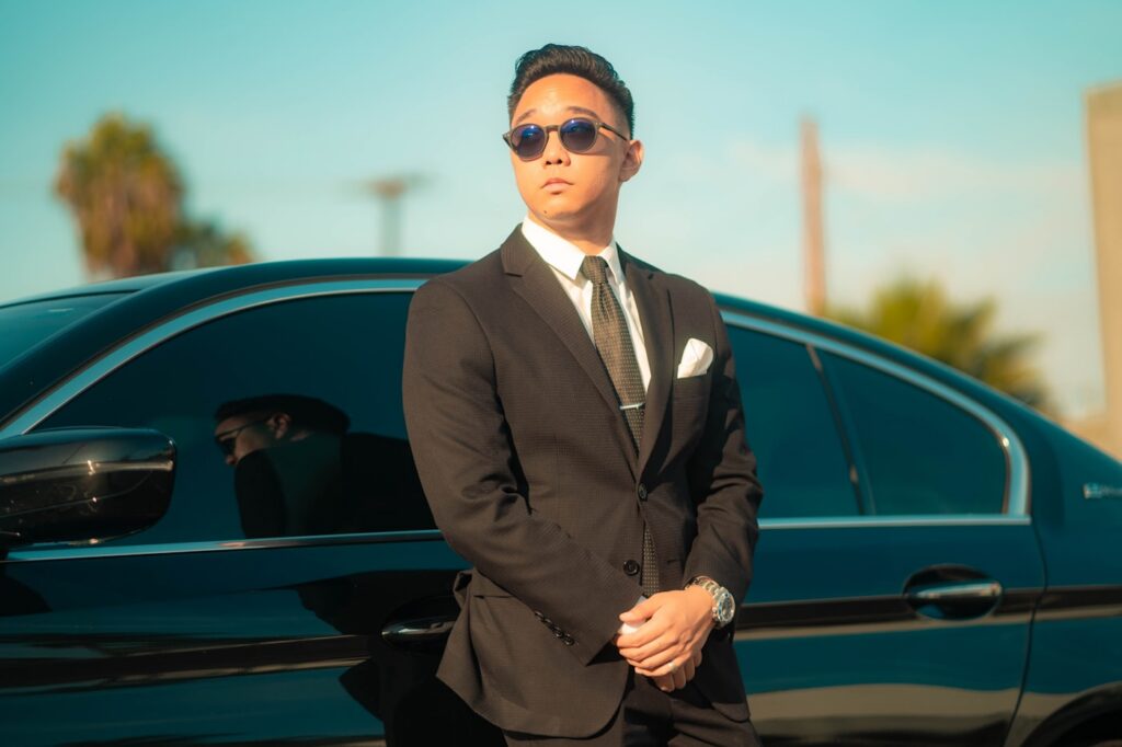 Protection agent in suit beside black executive vehicle